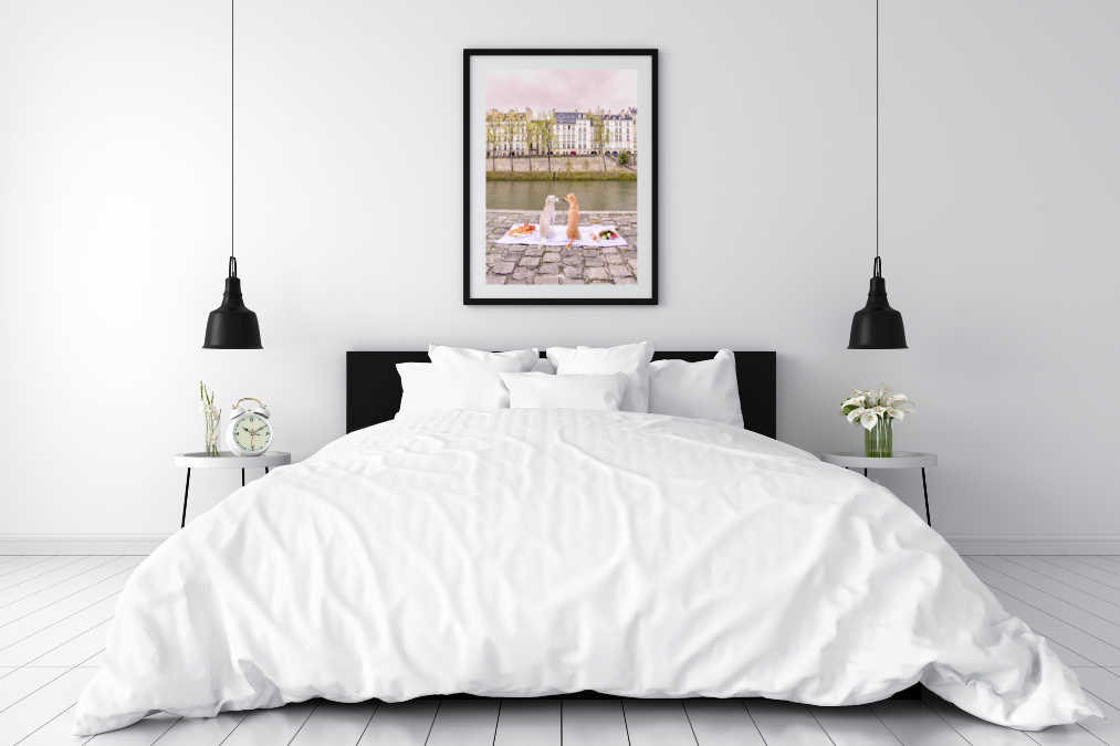 a bedroom with a framed photograph of two dogs