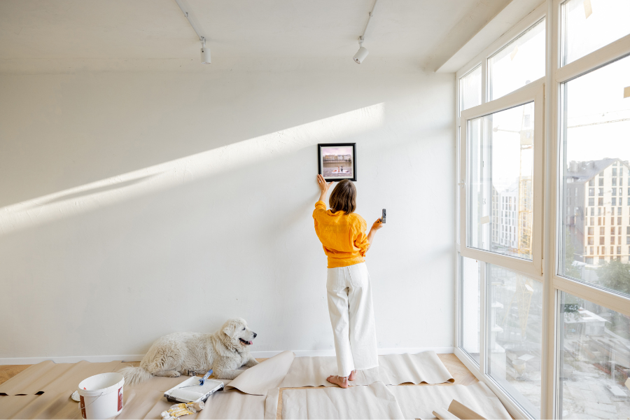 a woman hanging a picture