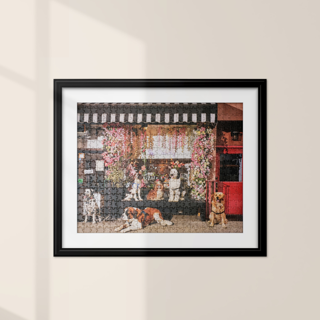 dogs in front of a pet bakery in a puzzle that is framed on a wall