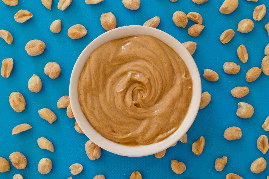 peanut butter and peanuts with a blue background